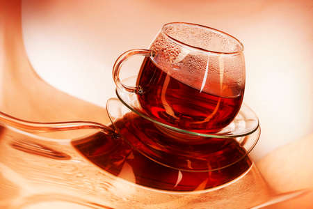 Cup of hot tea on a orange backgroundの写真素材