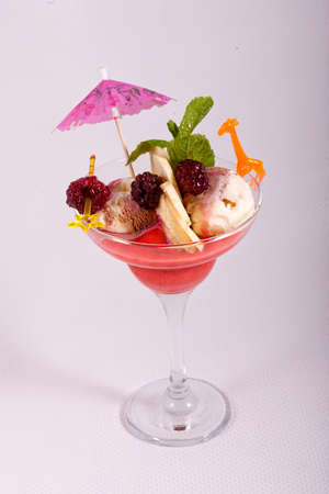 Dessert of ice cream, mint and fresh fruit in glass bowl on white backgroundの写真素材