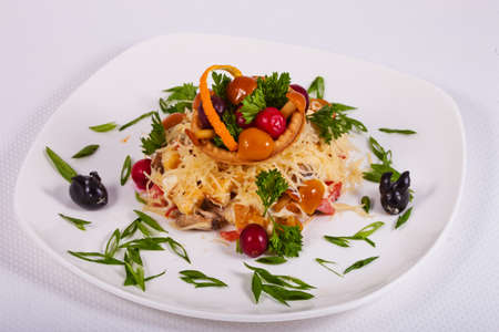 Fresh salad assorted with mushrooms, vegetables, meat, greens and cheese on white plateの写真素材