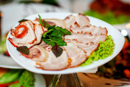 Delicious sliced ham roasted baked virginia with herbs on white plateの写真素材
