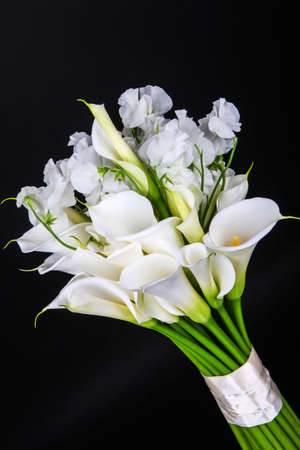 Bouquet of white calla lilies and eustoma on black background.の写真素材