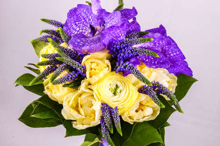 Beautiful bouquet flowers of white Ranunculus, iris purple iris, lupine on bright background.の写真素材