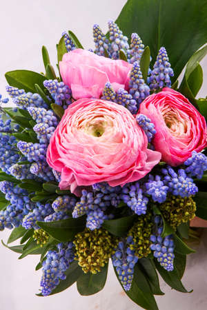 Beautiful bouquet flowers of white Ranunculus, iris purple iris, lupine on bright background.の写真素材