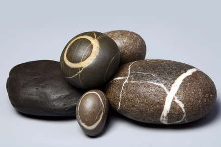 Set of striped rocks pebbles on grey background. Close-upの写真素材