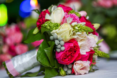 Wedding bouquet of bride colorful flowers roses on the white table