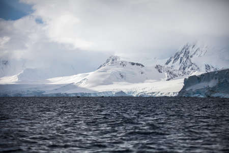 Fantastic landscapes of beautiful snow-capped mountains, rocks and ocean in Antarcticaの写真素材