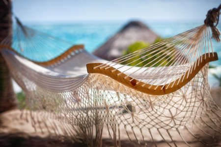 Empty hammock between two palm trees on the beach. Vacation conceptの写真素材