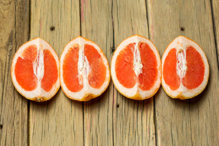 Sliced grapefruits on wooden background.