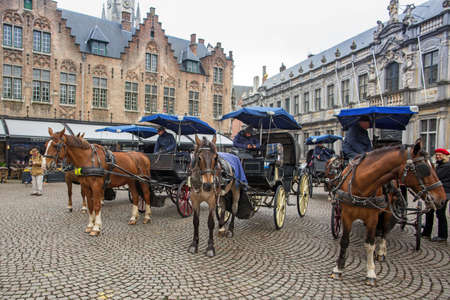 BRUGES, BELGIUM - APRIL 04. 2017: Horse carriage on Grote Markt square in Belgian city of Bruges.のeditorial素材