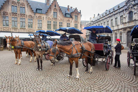 BRUGES, BELGIUM - APRIL 04. 2017: Horse carriage on Grote Markt square in Belgian city of Bruges.のeditorial素材