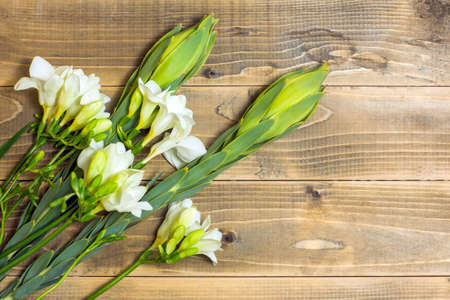 White Freesia flowers. Bouquet on wooden boards.の写真素材