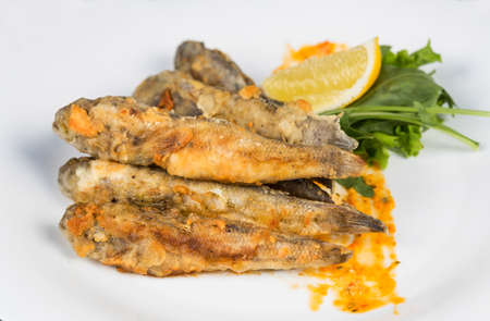 Fried fish gobies in batter with lemon and greensの写真素材