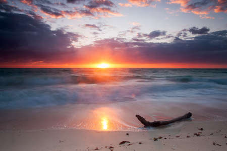 Sunrise in Cancun Mexico with sun rays coming through the cloudsの写真素材