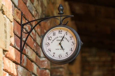 Old city street clock on a house wall