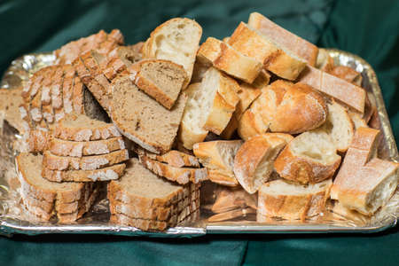 Loaf of bread cut into slices on cutting board