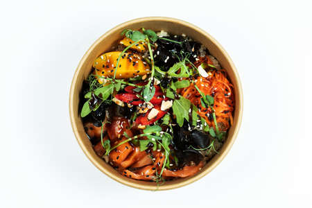 Hawaiian salmon fish poke bowl with rice, radish,cucumber, tomato, sesame seeds and seaweeds. Buddha bowl. Diet food