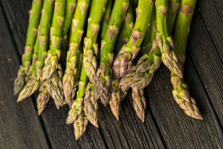 Bunch of fresh asparagus on wooden tableの写真素材