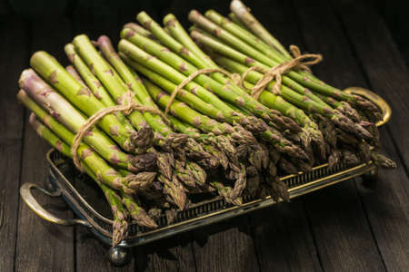 Bunch of fresh asparagus on wooden tableの写真素材