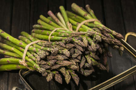 Bunch of fresh asparagus on wooden tableの写真素材