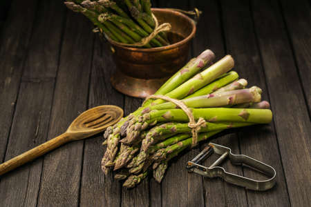 Bunch of fresh asparagus on wooden tableの写真素材