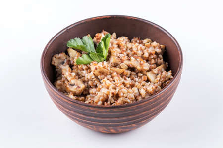 Buckwheat porridge with mushrooms in the frying pan on the tableの写真素材
