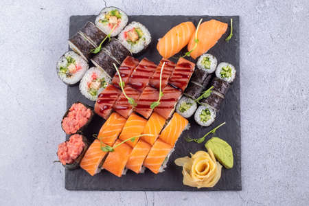 Sushi Set sashimi and sushi rolls served on stone slateの写真素材