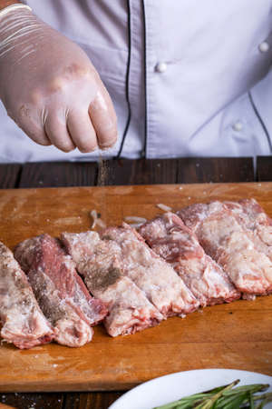 Preparation and cooking of pork ribs by a chef for a grill.の写真素材