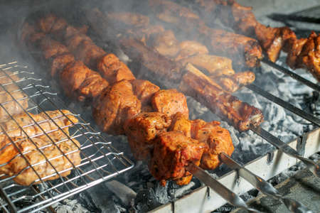 Grilling marinated shashlik on a grill. Shashlik is a form of Shish kebab