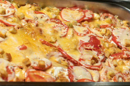 Baked cheesy meatballs casserole with tomato sauce in the oven dish.の写真素材