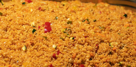 Easy bulgur pilaf pilavi with tomatoes in a ceramic bowl on a dark background close-up. Turkish cuisine, vegan food.の写真素材
