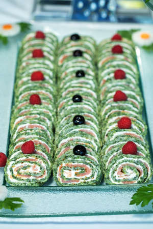 Rolls of thin pancakes with smoked salmon, cream cheese, chives and lettuce.の写真素材