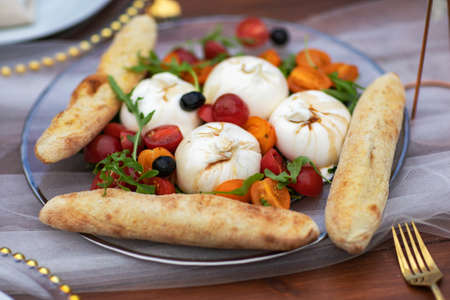 Suluguni sulguni cheese with tomatoes on white background. snack foodの写真素材