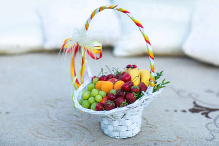 Basket and fresh fruits on tableの写真素材