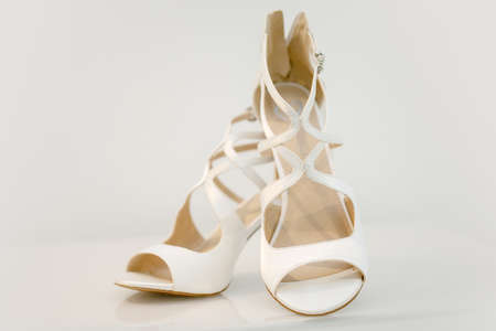 High heeled shoes on white table and beige dress indoors, closeupの写真素材