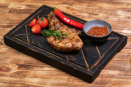 Juicy delicious ribeye or tomahawk steak on the bone with baked potatoes, spices and herbs. Hearty meat dishの写真素材