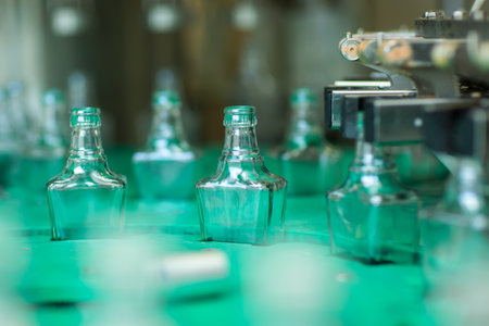 Bottles with a drink closed with a screw cap. Factory for the production of alcoholic beveragesの写真素材