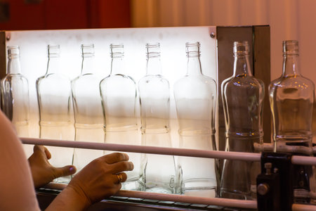Small liquor production based on maple syrup. Lot of pure alcohol bottles unlabeled. Bottles placed...