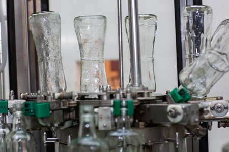 The machine for washing glass bottles. Factory for bottling alcoholic beverages.の写真素材