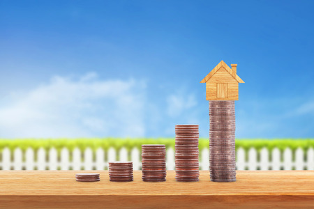 Coins money and house model on row of coin money for finance and banking. Concept for property ladder, mortgage and real estate investment .Investment and saving conceptの写真素材