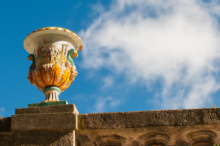 View of a colored ceramic vase from Caltagirone used as an ornament in the main public gardens of the town with blue sky and clouds in the backgroundの写真素材