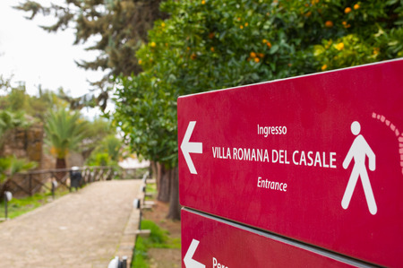 Red tourist info sign at the entrance of the famous Villa romana del Casale in Piazza Armerina, Sicilyの写真素材