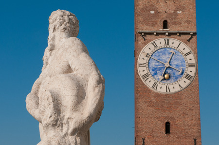 Statues on the top of the Basilica palladiana, the main monument of the town Vicenza and the clock towerの写真素材