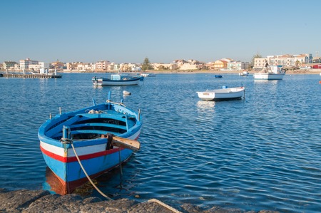 Fishing boats in the small harbour of the sea village Marzamemi, Southeast Sicily, in the early morningの写真素材