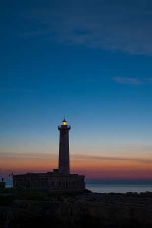 Lighthouse and starrry night before the sunriseの写真素材