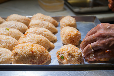 Just filled sicilian arancini with their typical pyramidal shape before being friedの写真素材