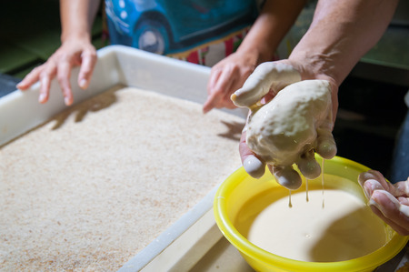 Sicilian cook dunking the just filled arancini in the beaten eggsの写真素材
