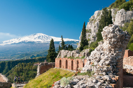 Section of the upper perimetral arcade of the greek theater of Taormina, Sicily, with snowy mount Etna in the backgroundの写真素材