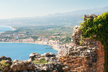 Section of the upper perimetral arcade of the greek theater of Taormina, Sicily, with a view of Giardini Naxos in the backgroundの写真素材