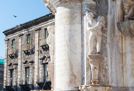 One of the two small statues at the bottom of the lava stone elephant in the main square of Catania, Sicilyの写真素材