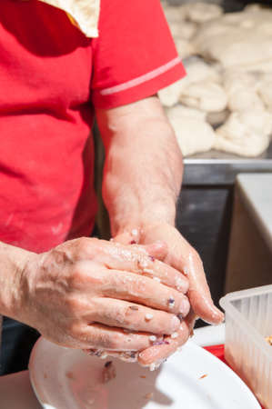 A sicilian cook making a typical rice arancino with chicory and walnuts